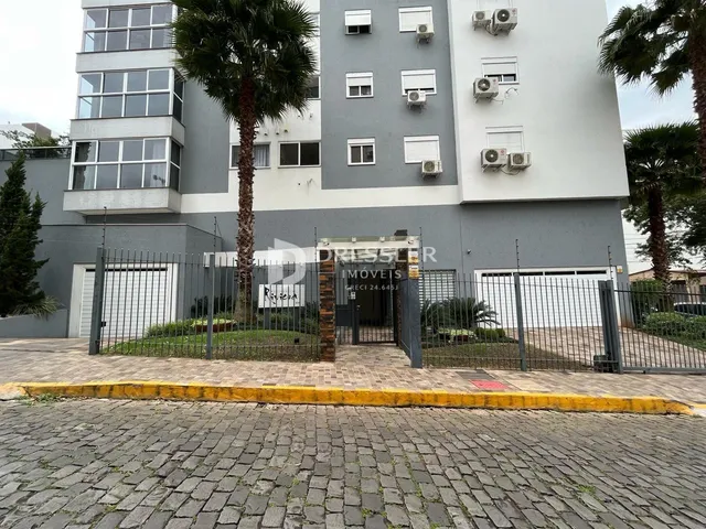 Fachada de um prédio residencial em Lajeado, Brasil, com muro e portão.