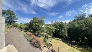 Vista externa da propriedade mostrando uma área gramada e vegetação ao longo de um caminho.