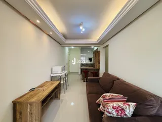 Interior de uma sala de estar com sofá e móveis de madeira clara.