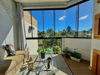 Sala de estar com grande janela de vista para a natureza.