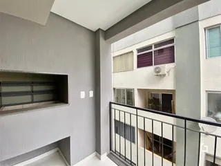Vista interna de um corredor com sacada em um imóvel.
