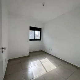 Ambiente interno com paredes brancas e piso de cerâmica.