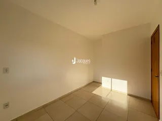Interior de uma sala com paredes brancas e piso de cerâmica.