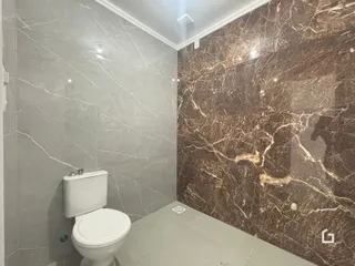Banheiro com revestimento de azulejo nas paredes e piso.