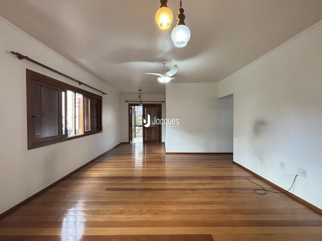 Hall de entrada com piso de madeira e janela.