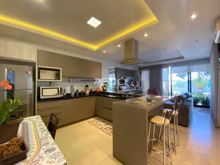 Vista de uma cozinha moderna com ilha e área de jantar em Lajeado.