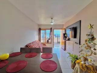 Ambiente interno de uma sala com piso de madeira e sofá.