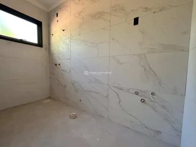 Parede interna com acabamento em mármore claro em um imóvel.