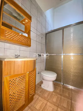 Foto de um ambiente interno de banheiro com piso de cerâmica e móveis de madeira.