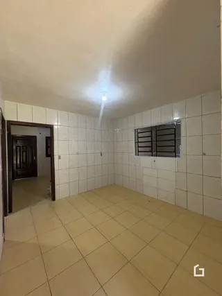 Interior com piso de cerâmica e paredes brancas em uma residência.