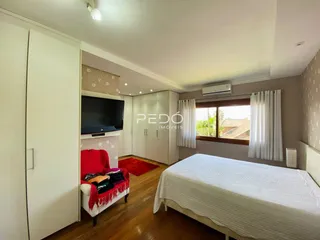 Quarto com cama, armário e piso de madeira.