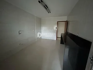 Hall de entrada com paredes brancas e piso claro.