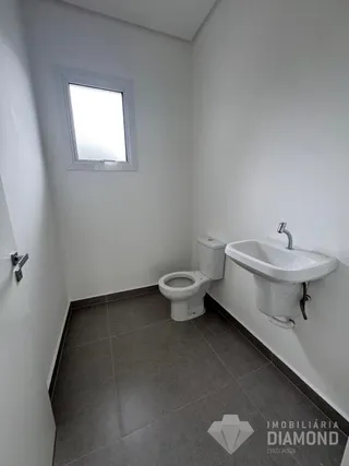 Foto de um banheiro interno com paredes brancas e piso de cerâmica.