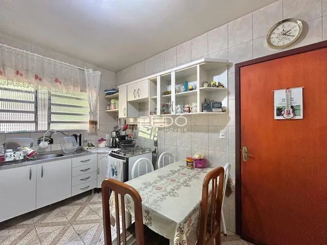 Foto de uma cozinha com armários brancos e piso de cerâmica.