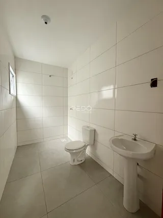 Foto de um banheiro com revestimento de cerâmica branca nas paredes e piso.