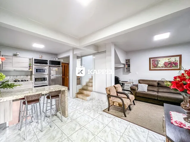Foto de uma sala de estar e cozinha com armários e móveis.
