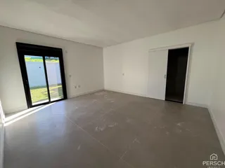 Esta é uma sala ampla com piso de concreto e porta de vidro voltada para o exterior.