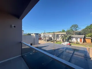 Vista da varanda com grade de vidro.