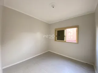 Uma sala interna com paredes brancas e piso de cerâmica.