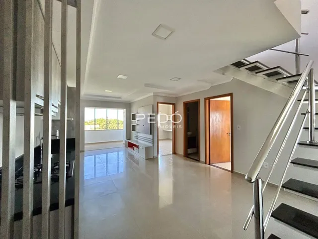 Hall de entrada com escadaria e portas de madeira em um imóvel no Brasil.