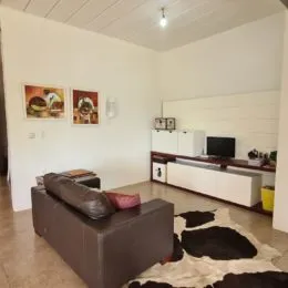 Foto de uma sala de estar com um sofá grande e paredes brancas.