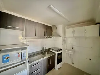 Foto de uma cozinha com armários e bancada em um imóvel no Brasil.