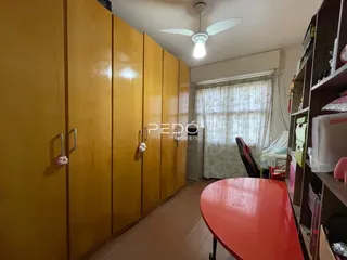 Quarto com armários amarelos e móveis de madeira na sala.