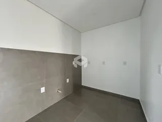 Vista interna de um ambiente com paredes brancas e piso cinza escuro.