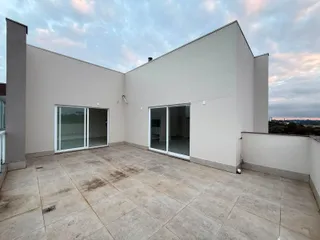 Vista externa de uma área de lazer com piso de concreto em uma residência.