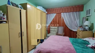 Quarto com armários em madeira e cama rosa.
