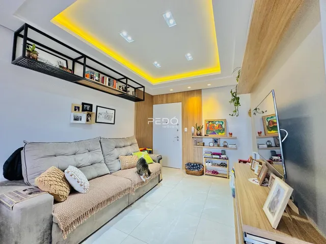 Sala de estar moderna com sofá e estantes de madeira em um imóvel no Brasil.