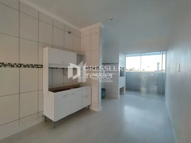 Interior de um ambiente com paredes brancas e armários brancos.