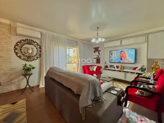 Sala de estar com sofá e televisão em um imóvel no Brasil.