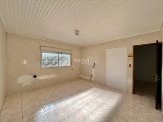 Ambiente interno de uma sala com piso de cerâmica e paredes claras.