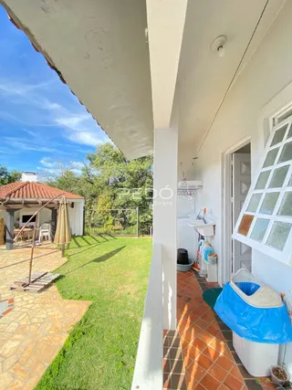 Vista do quintal com gramado e área pavimentada.