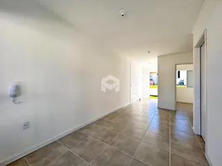Hall da casa com piso de cerâmica e paredes brancas.