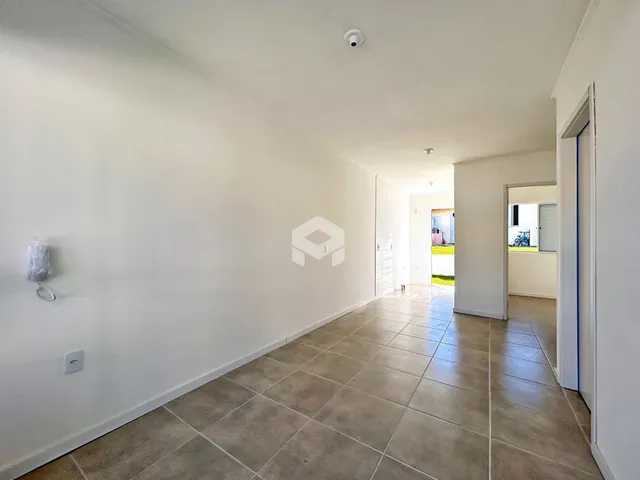 Hall da casa com piso de cerâmica e paredes brancas.