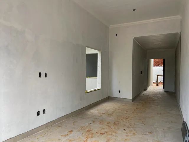 Hall de corredor interno com paredes brancas e piso claro.
