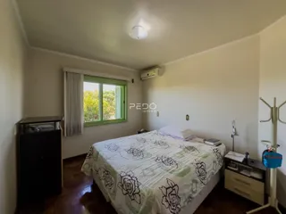 Quarto com cama e janela de madeira no imóvel.