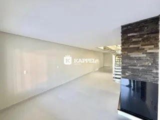 Hall de entrada longo e bem iluminado com parede de pedra escura na lateral.