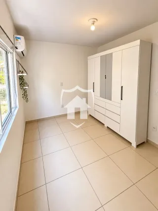 Quarto com piso de cerâmica e armário embutido branco.