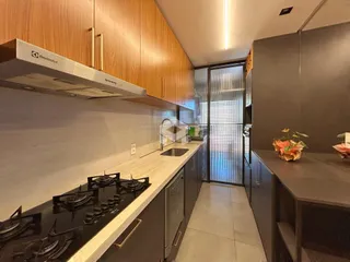 Cozinha moderna com armários de madeira e bancadas claras.