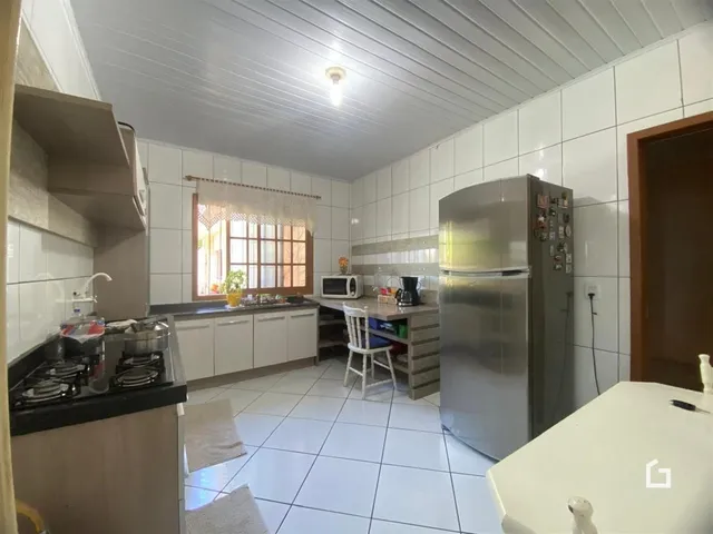 Imagem de uma cozinha com piso de cerâmica e paredes brancas.