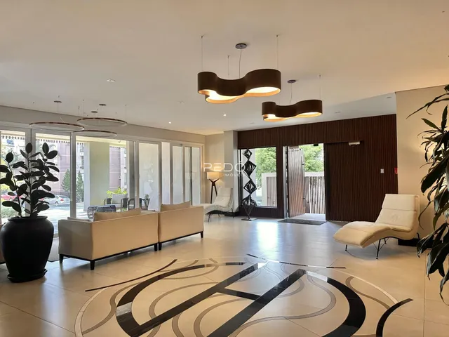 Sala de estar moderna com piso em padrão geométrico e grandes janelas.