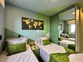 Quarto com duas camas de solteiro e paredes verdes.