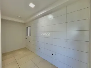 Corredor interno com paredes brancas e piso de cerâmica.