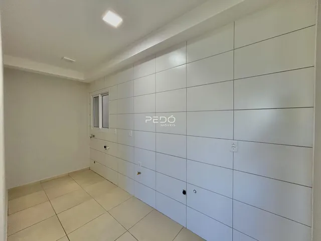 Corredor interno com paredes brancas e piso de cerâmica.