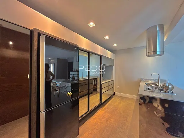 Ambiente interno moderno com portas de vidro que se abrem para outra área.