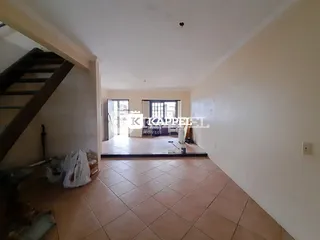 Uma foto interna mostra um ambiente com piso de cerâmica e escadaria.