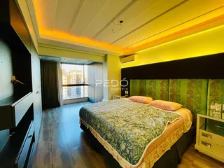 Quarto com cama grande e piso de madeira em um imóvel no Brasil.